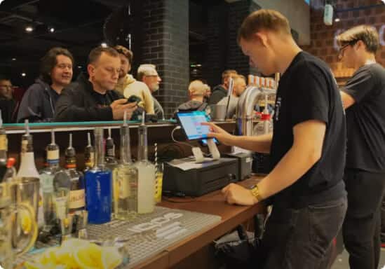 Barman obsługujący klientów przy barze z systemem POSbistro